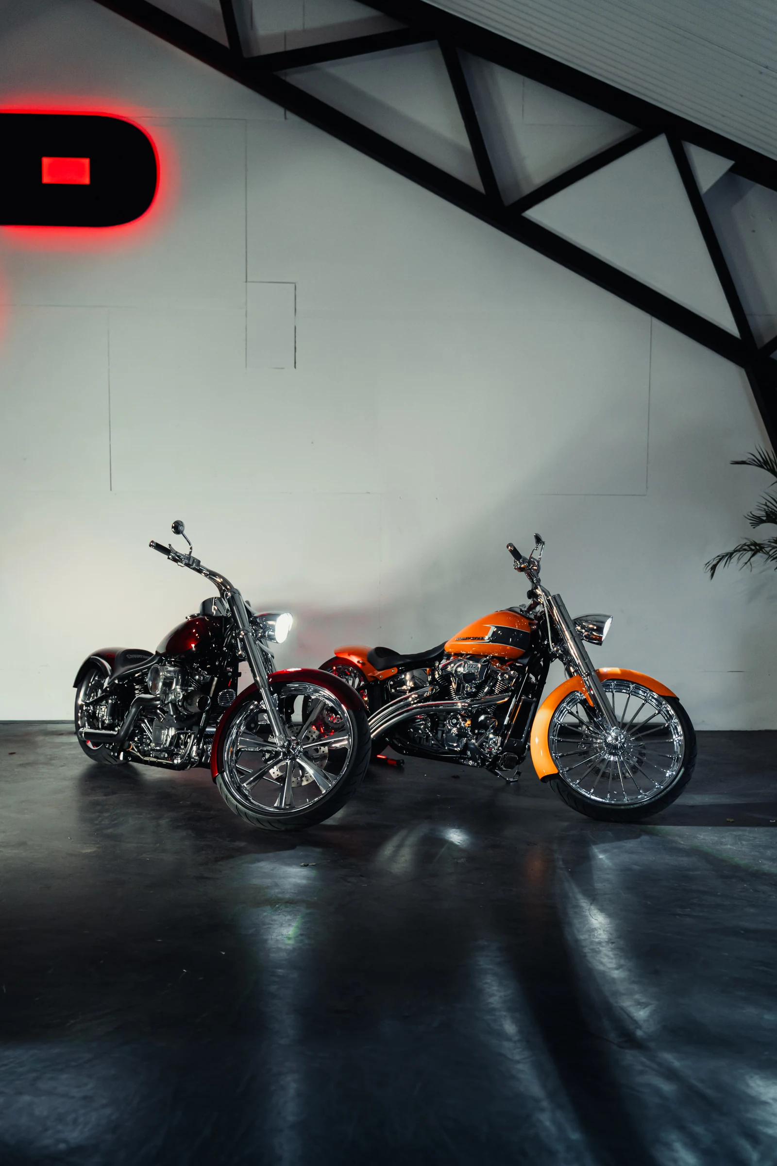 Two custom Harley-Davidson Breakouts, maroon and orange, side by side at the Fyshwick studio